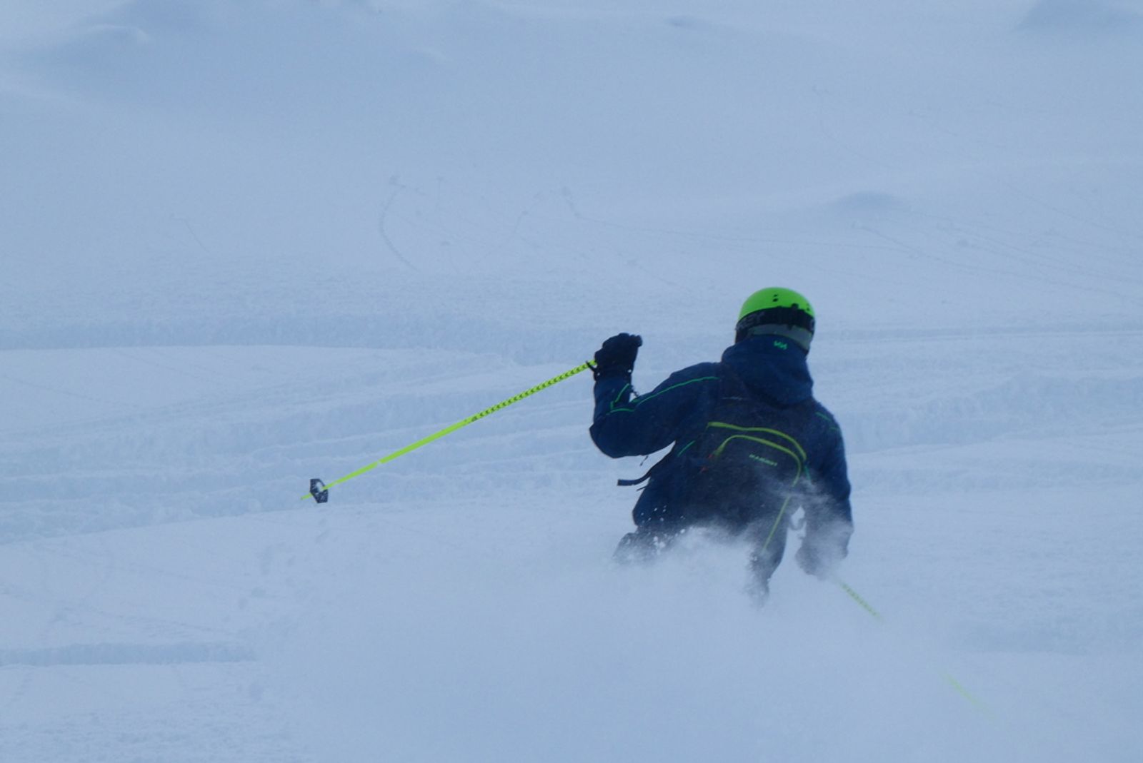 Skieur au casque vert plongeant dans la poudreuse à La Grave.