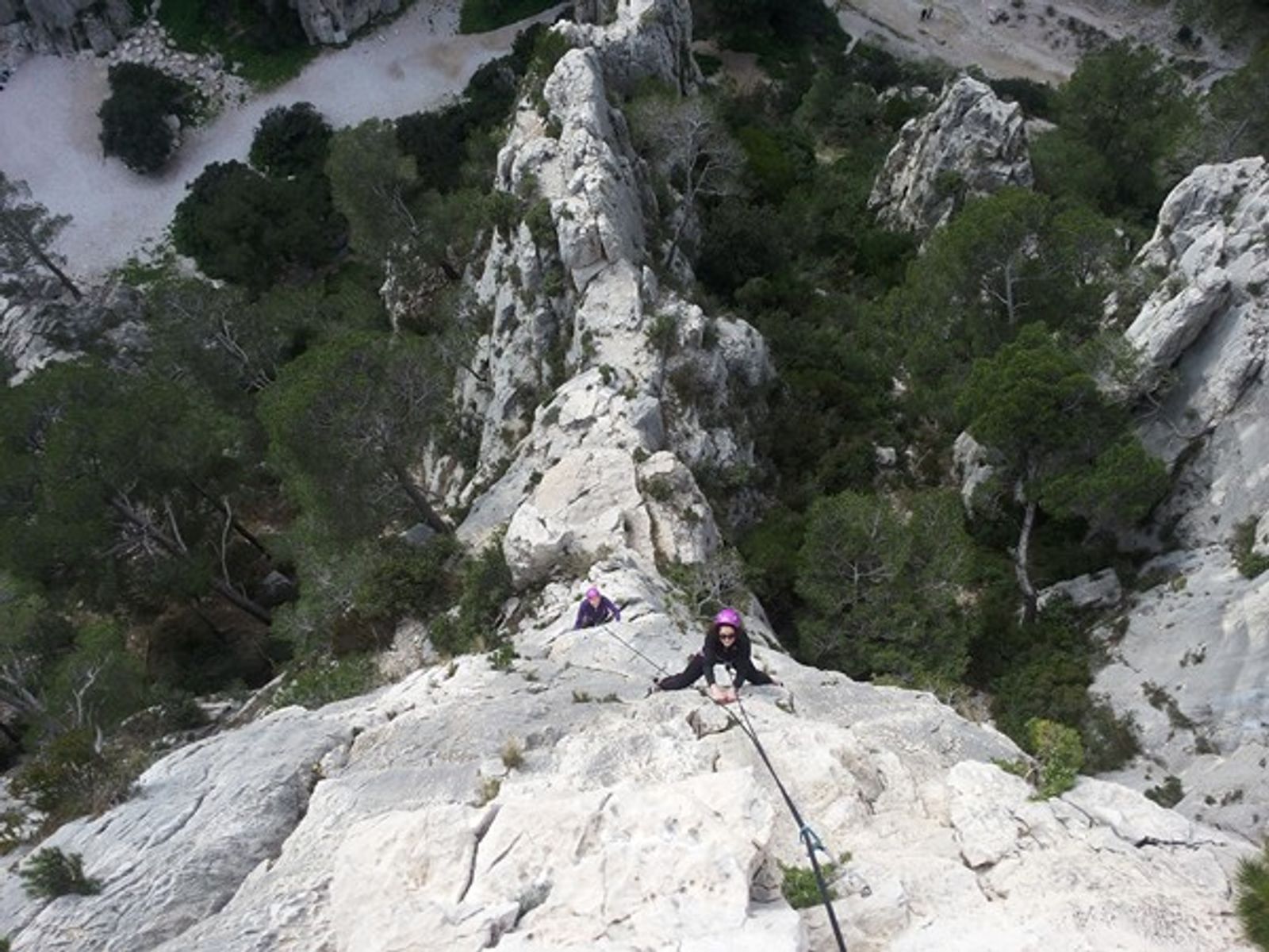 Vue plongeante sur une grimpeuse encordée sur l’arête calcaire de la Saphir