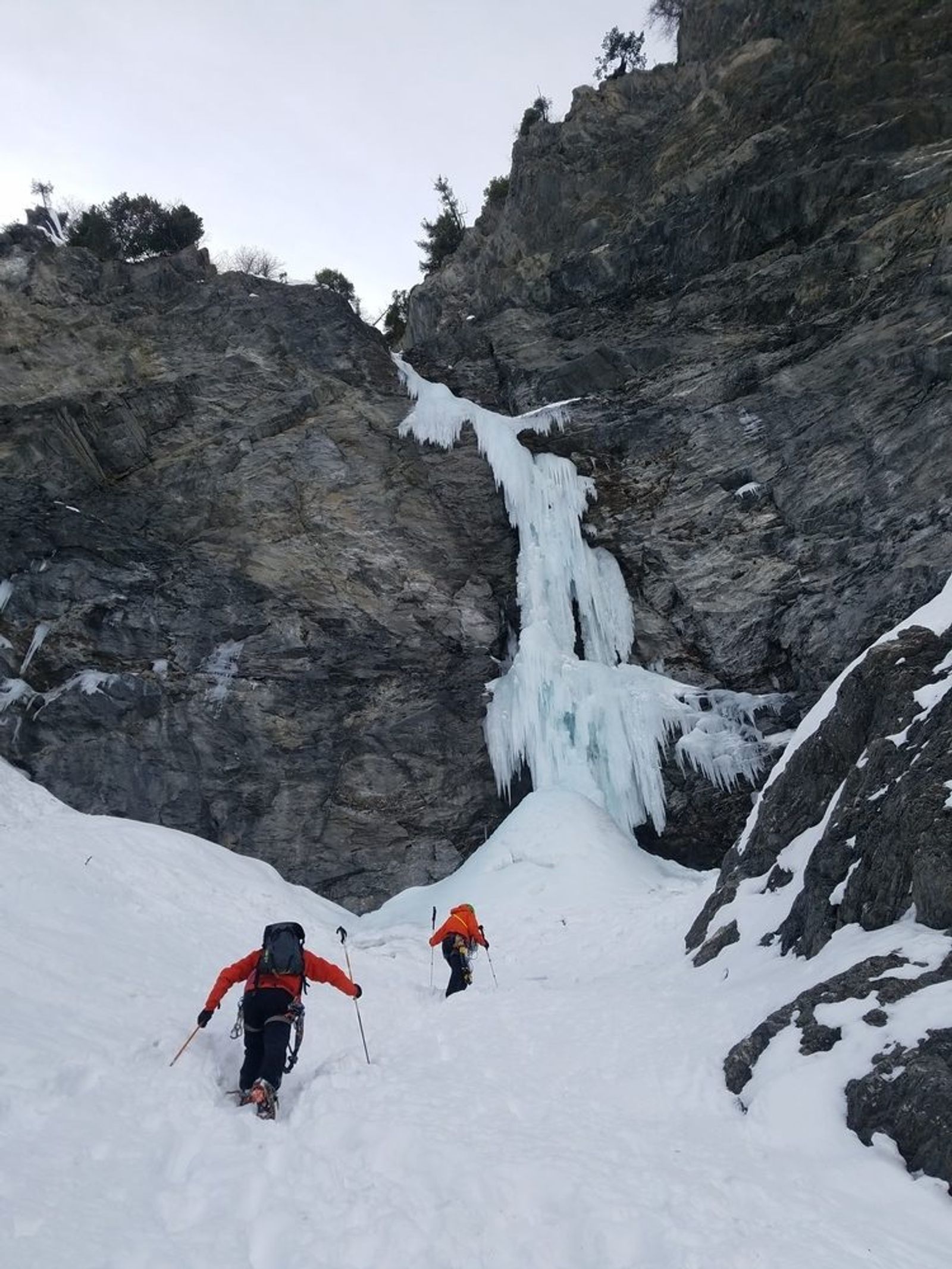 Deux grimpeurs encordés progressent dans une cascade de glace du Val Argentera.