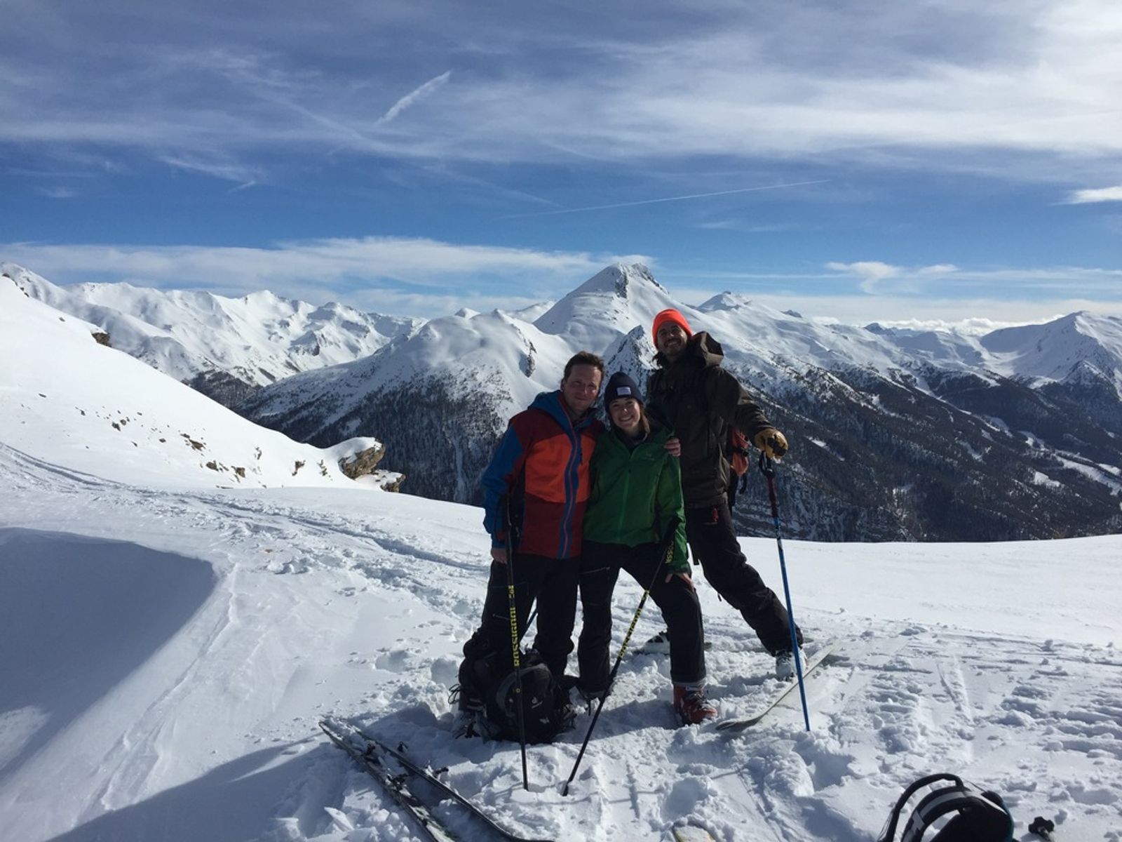 Three skiers posing on a snow ridge