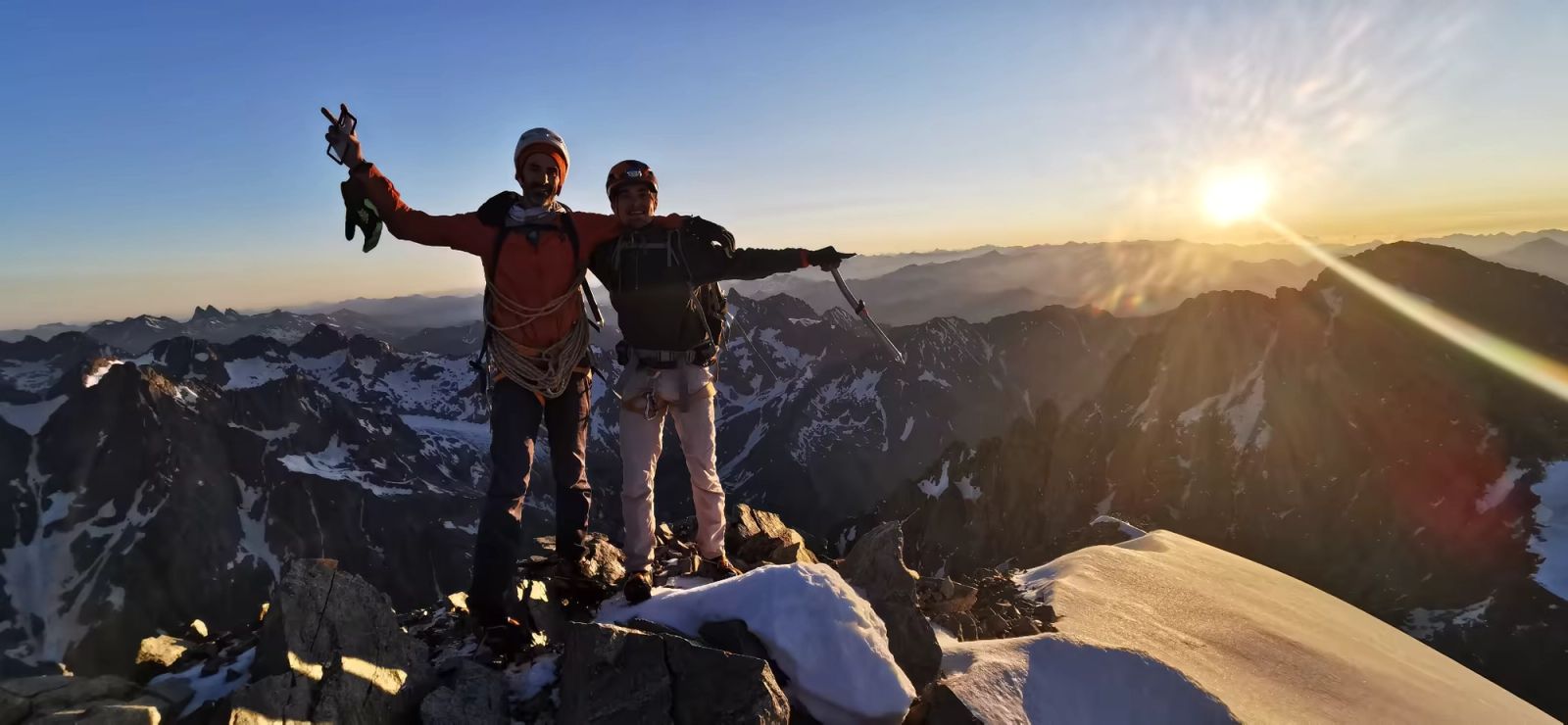Deux alpinistes au sommet du Pelvoux au lever du soleil avant leur vol en parapente