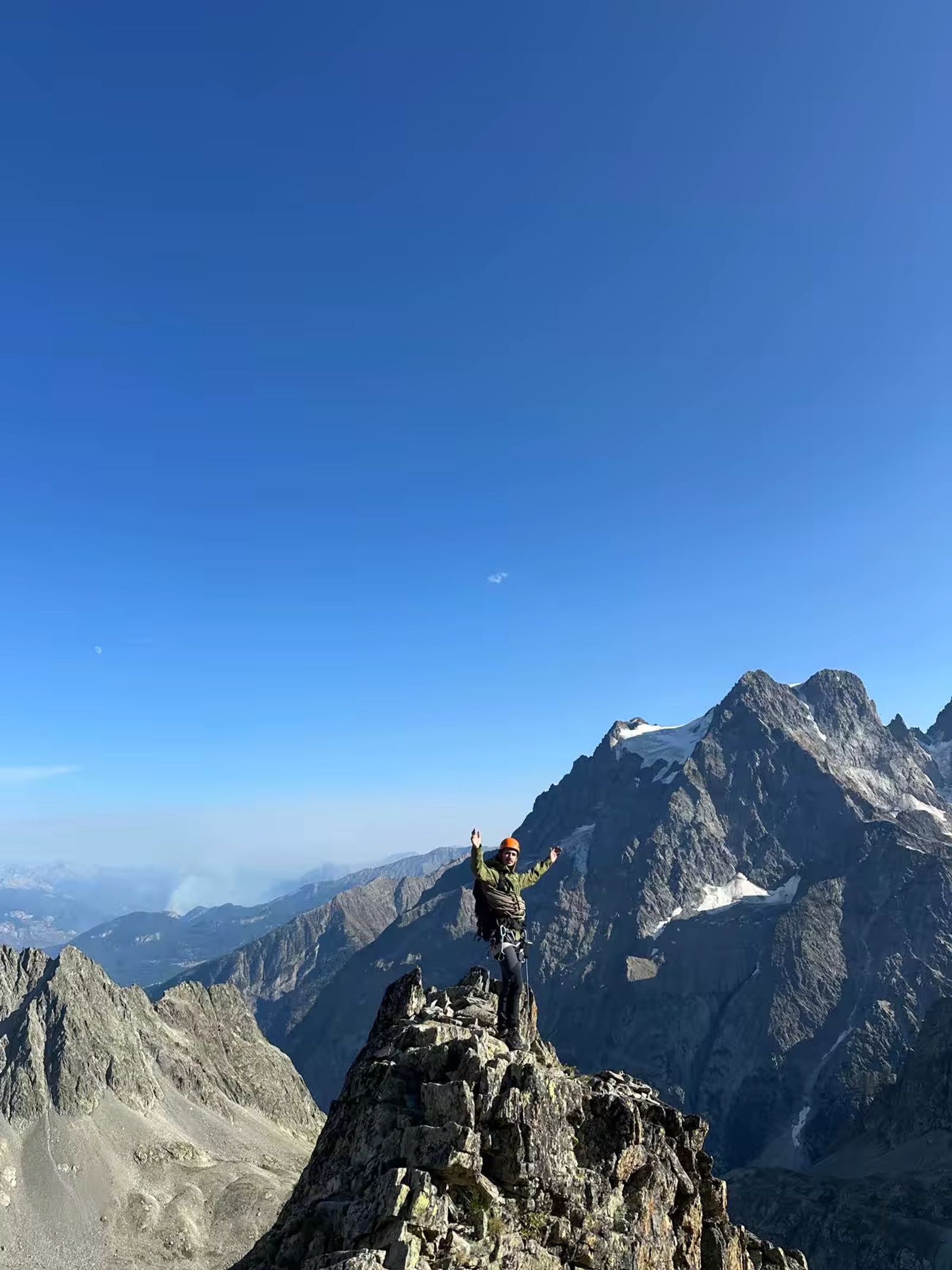 Alpiniste au sommet d’une arête rocheuse pendant une course d’application dans les Écrins