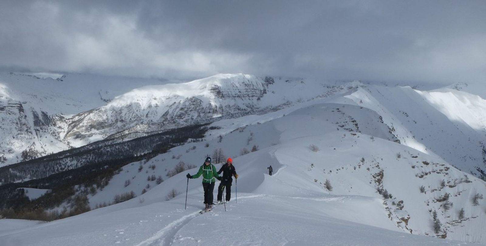 Two skiers climbing a very scenic ridge