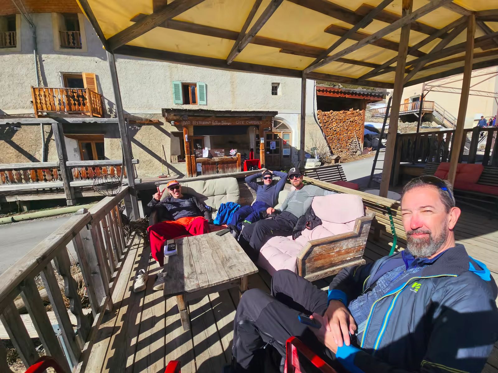 4 skieurs posés confortablement sur la terrasse ensolleillée du Gîte des Granges à Fouillouse
