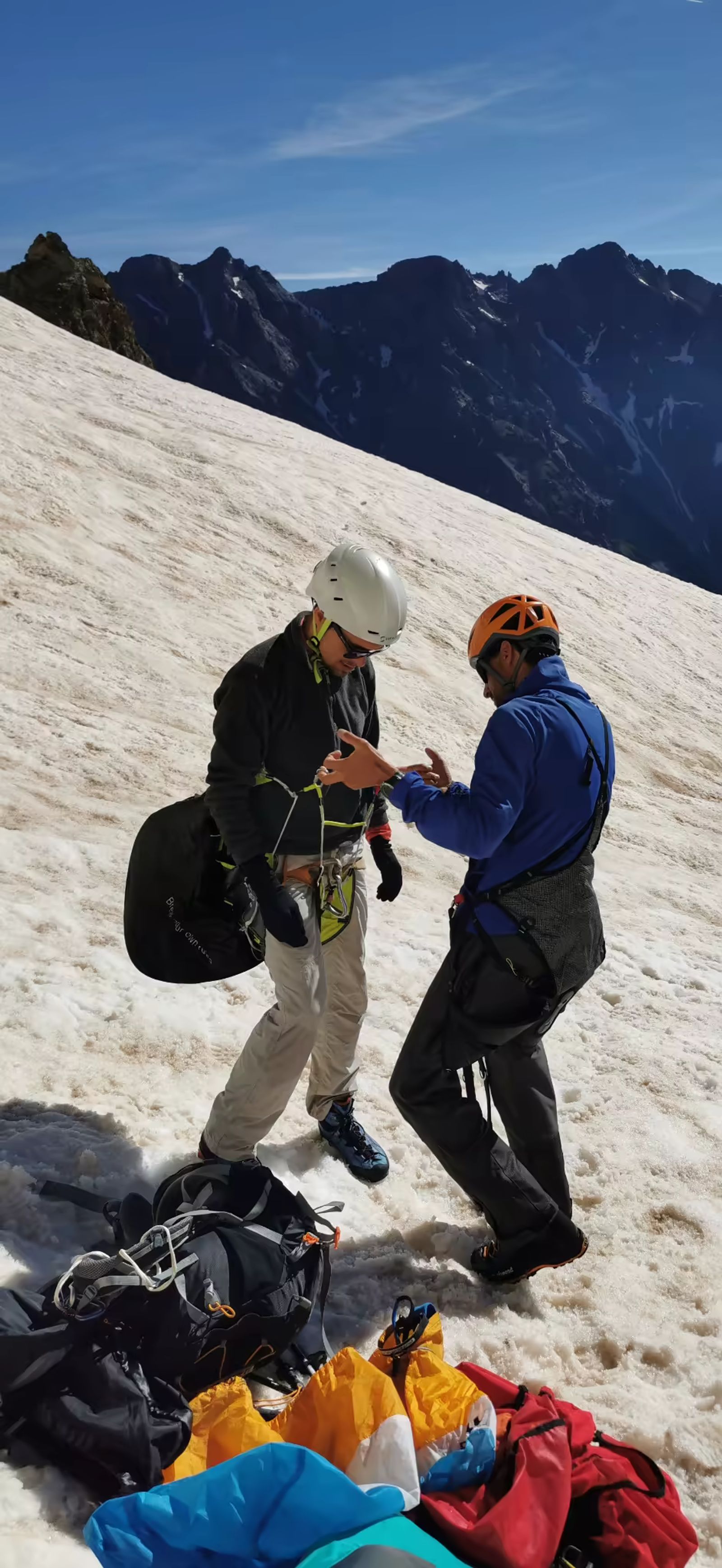 Préparation du matériel de parapente sur la neige avant le décollage du Pelvoux