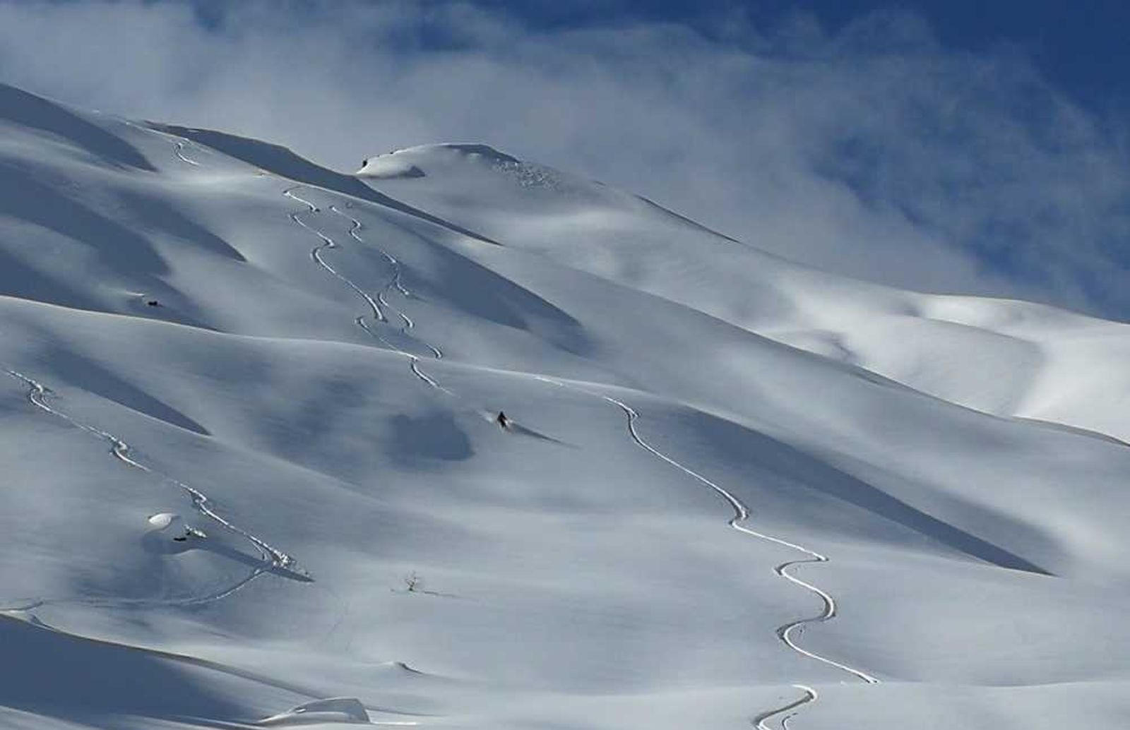 Traces laissées par deux skieurs dans une face enneigée