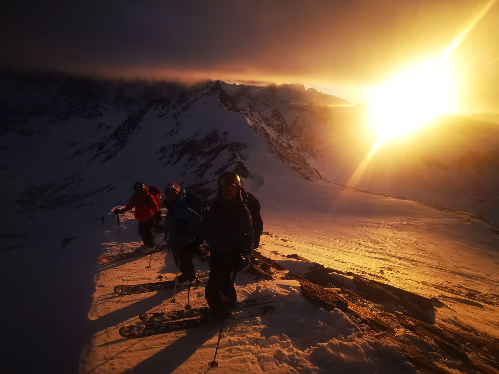 Groupe en montée à ski au coucher du soleil dans le massif des Cerces