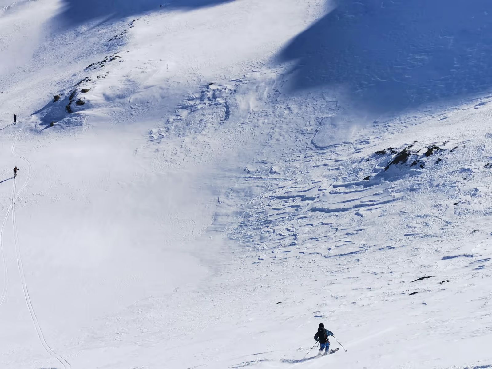 Skieur descendant une grande pente enneigée dans le Mercantour