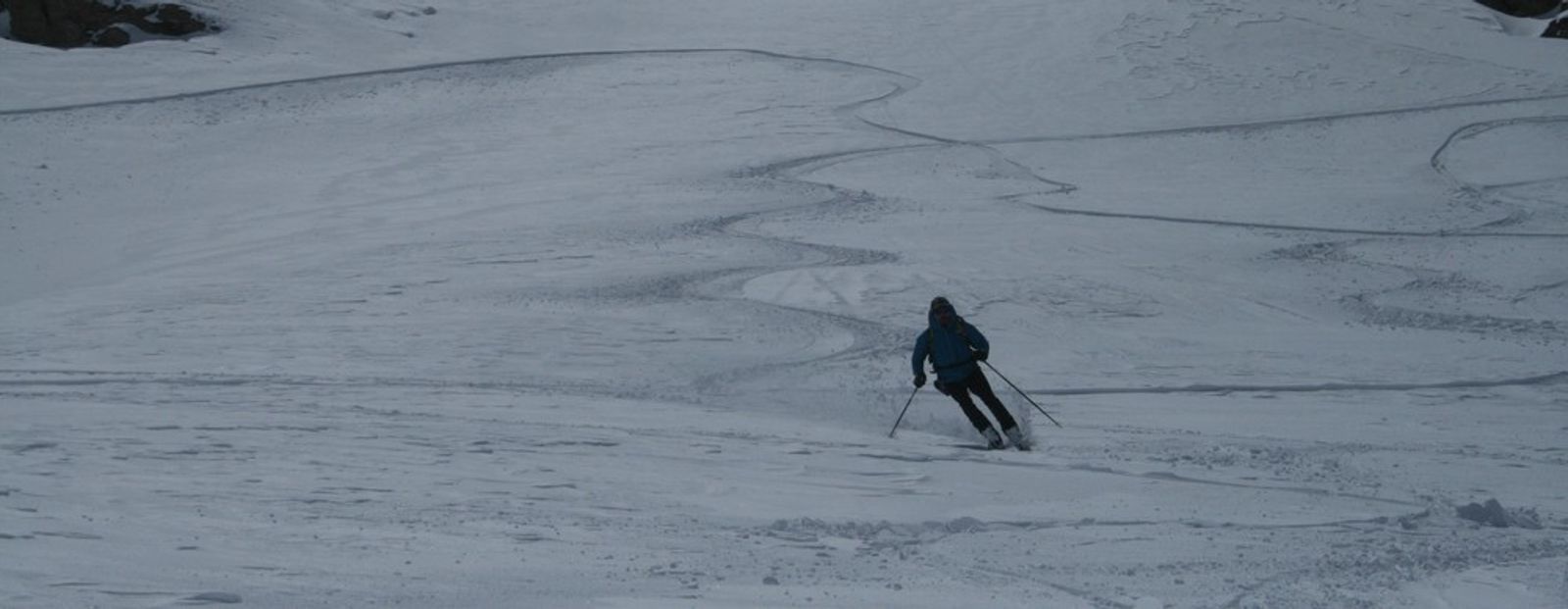 A skier carving through the tracks left by others on the descent at the Cime du Grand Vallon.