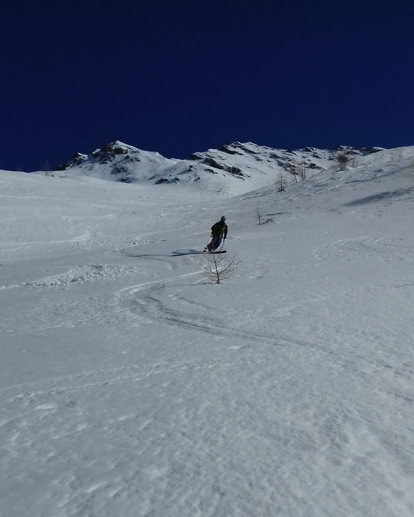 Skieur et traces de virages dans la poudreuse de la face nord-ouest du Maït d’Amunt.