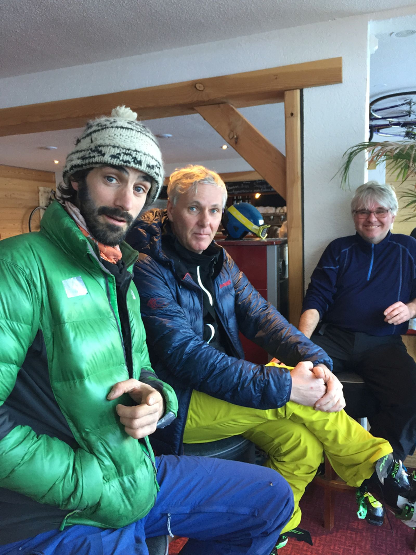 Trois compagnons de ski assis en terrasse pendant une pause après-ski.