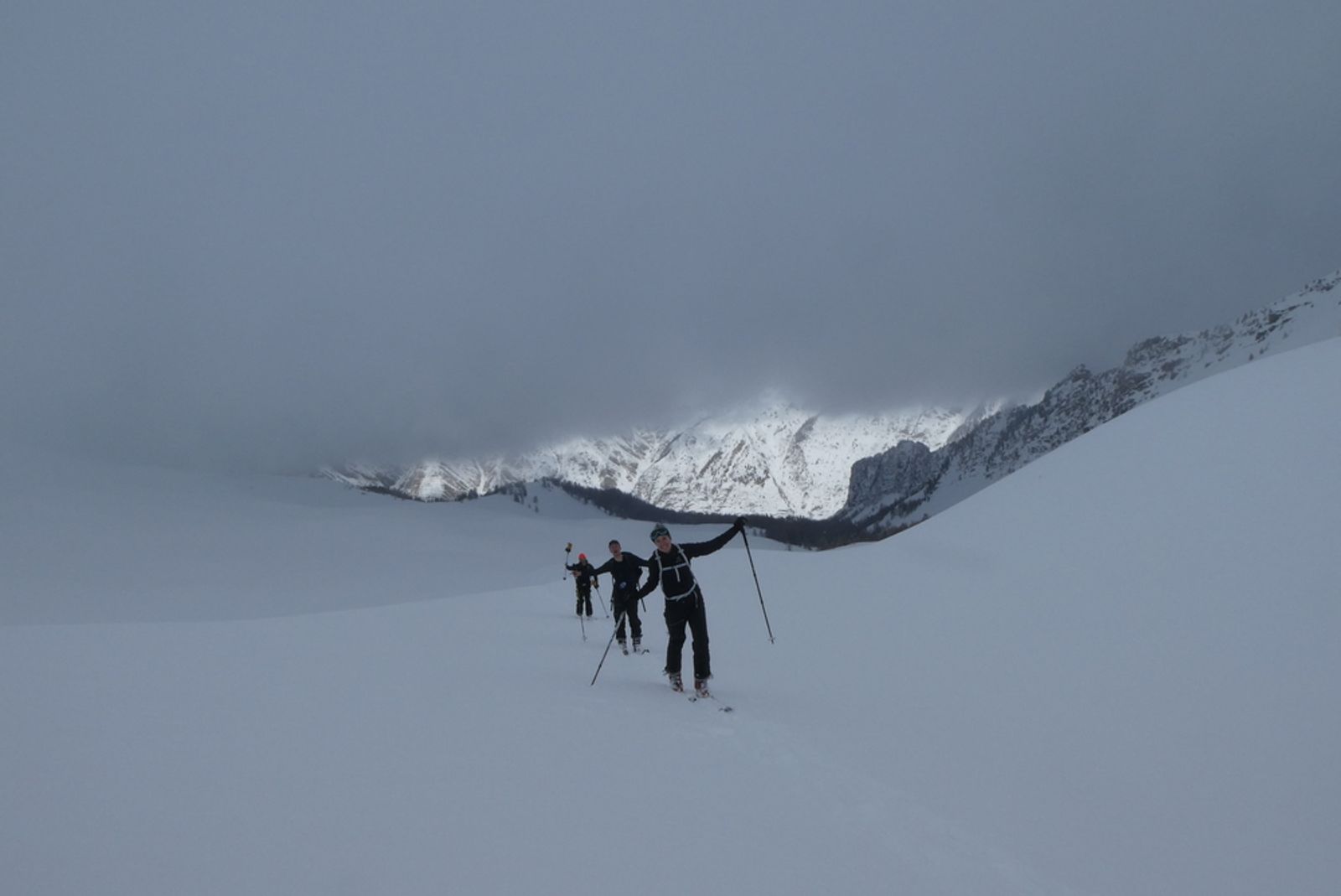 Skiers ascending with the edge of the cloud right above them