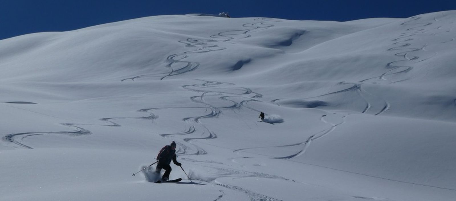 Skieur dessinant une nouvelle trace dans la poudreuse sous la Blanche.