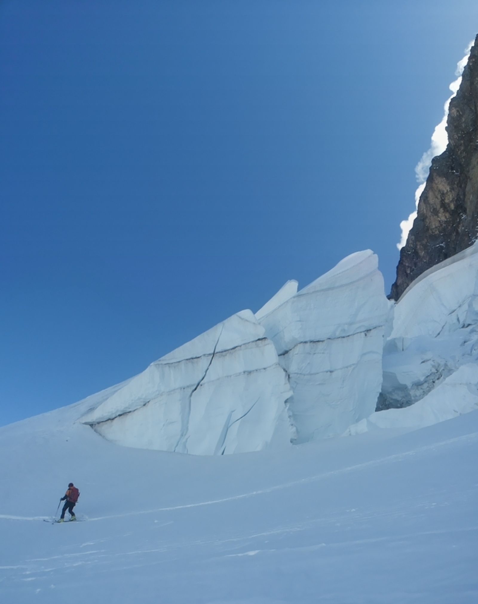 Skieur passant sous sérac pendant le contournement de la face nord de la Meije