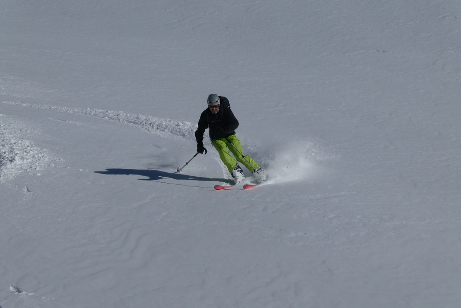 Frank en pantalon vert skie la poudreuse de la combe du Ravin Noir.