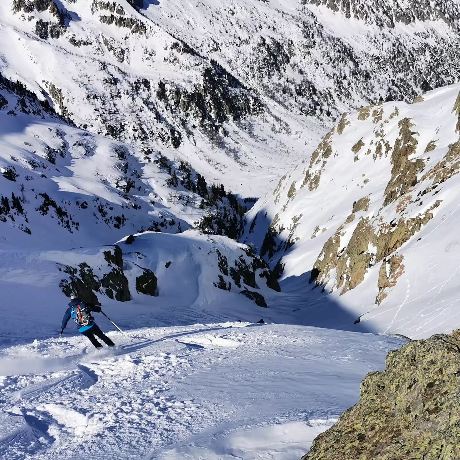 Skieur descendant une pente raide en poudreuse dans le Mercantour