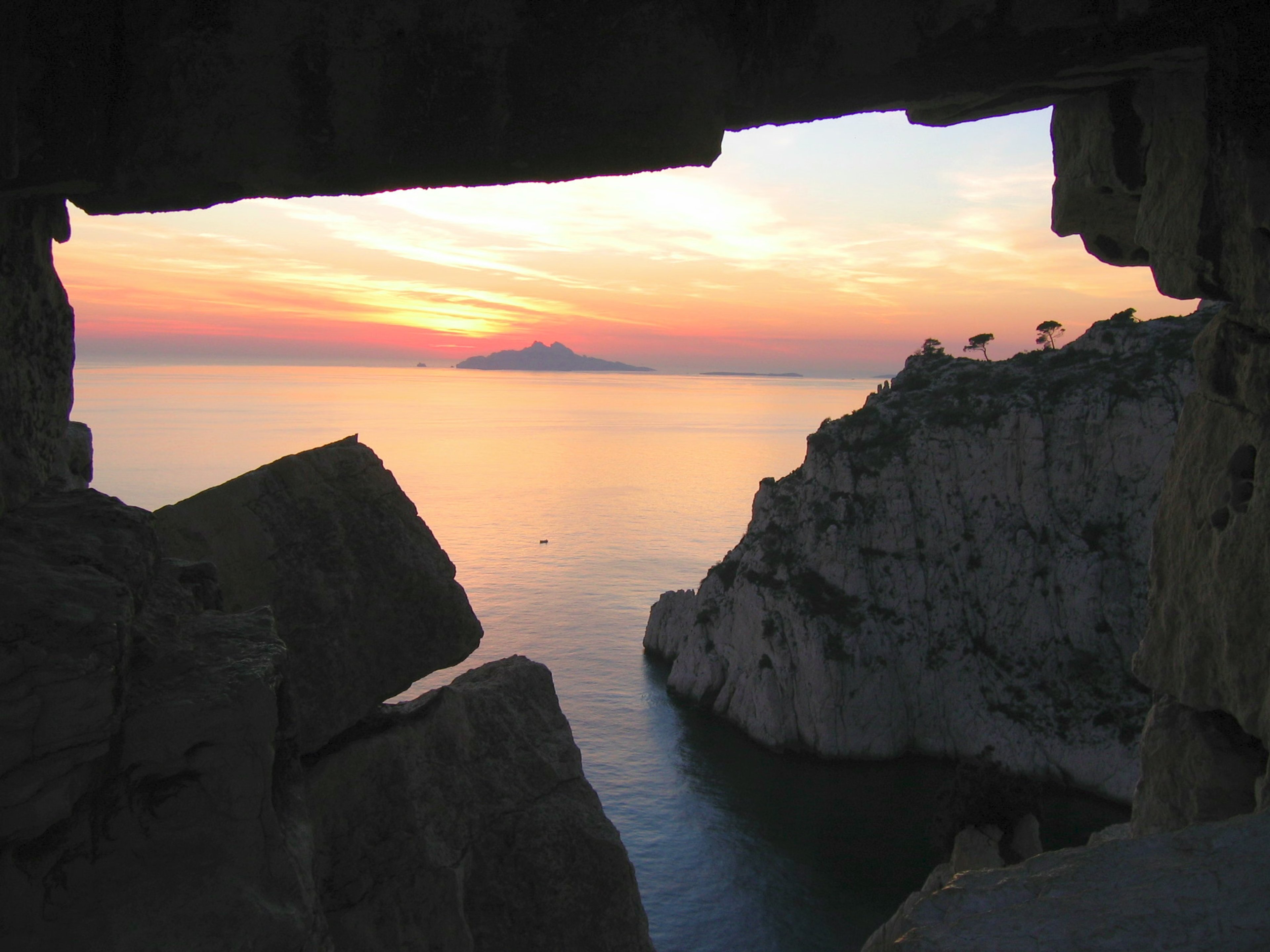 Vue sur la mer au crépuscule à travers une ouverture rocheuse dans les Calanques.