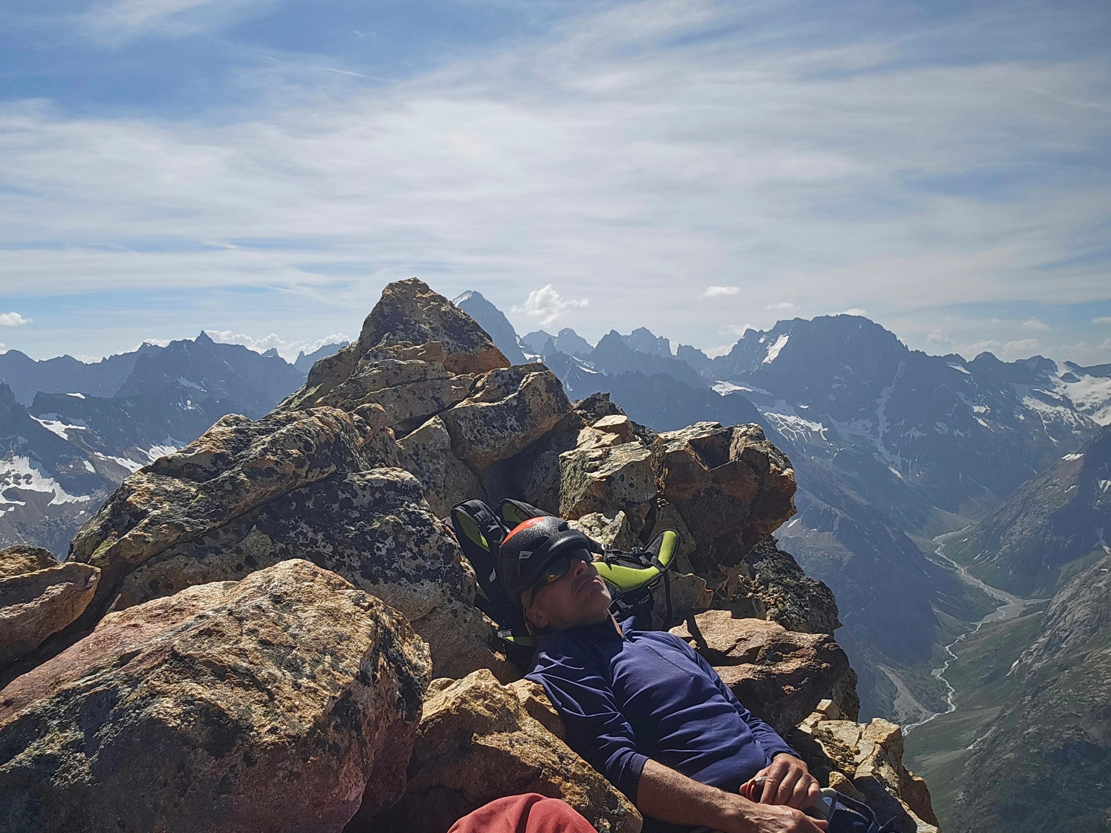 Alpiniste à la sieste sur le sommet du Rouget, panorama sur les Écrins