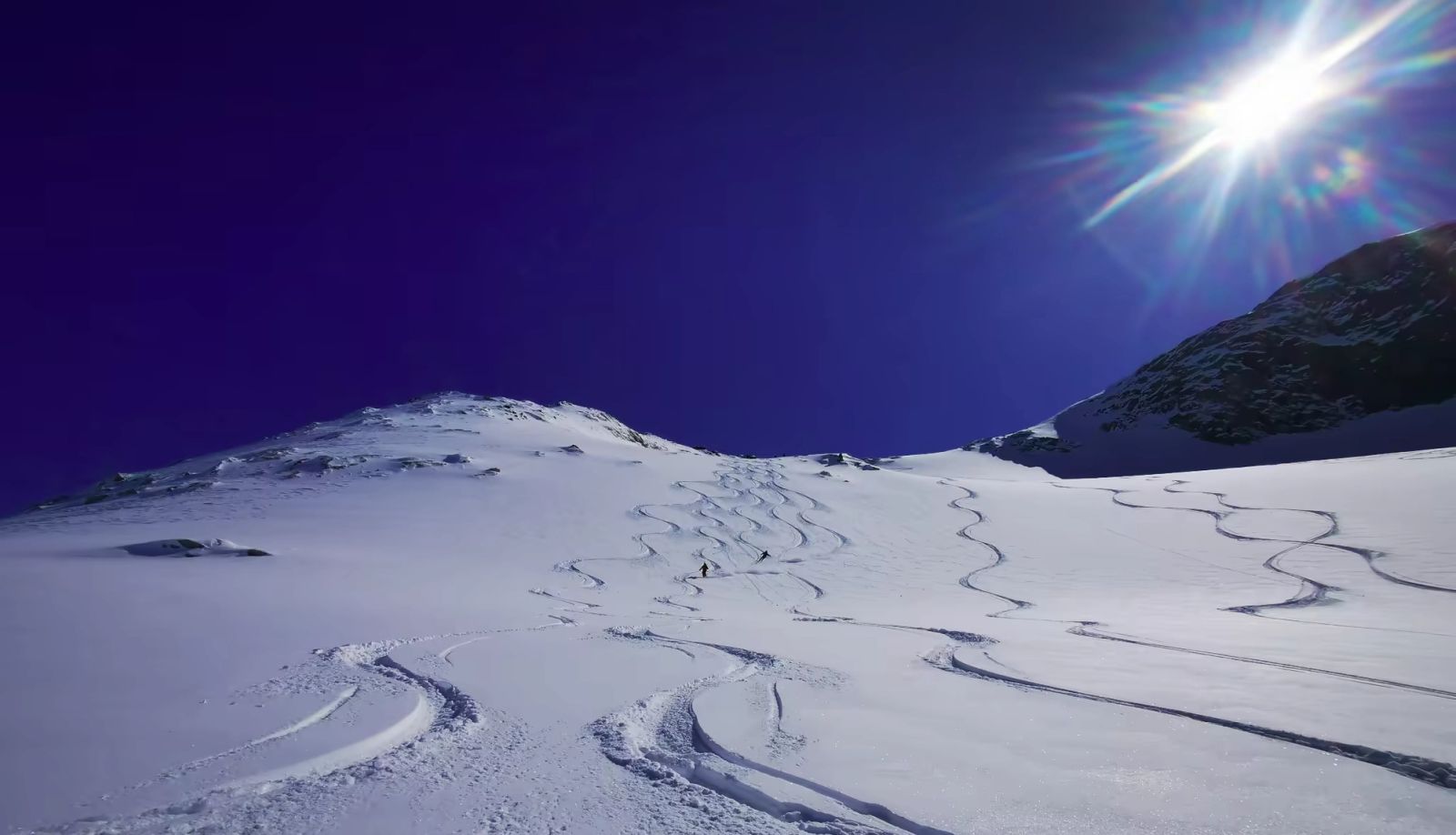 Traces de ski sur une pente ensoleillée au-dessus des fjords du Groenland