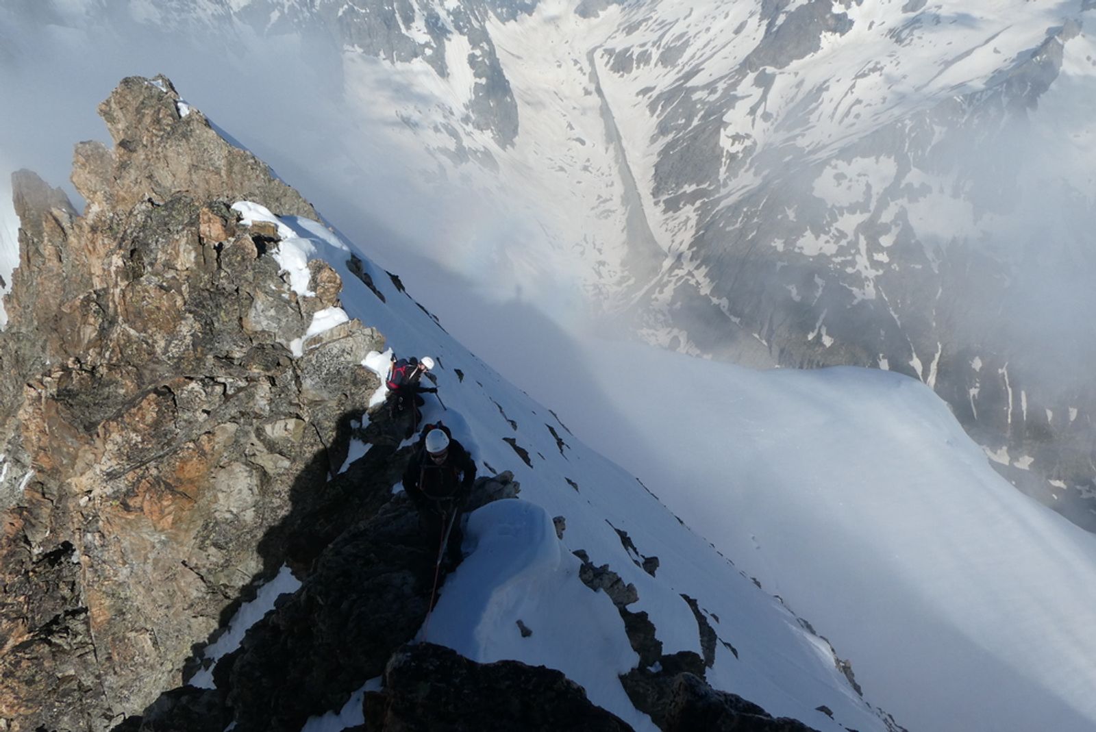 Une arête mêlant rocher et neige disparaît dans la brume pendant la traversée Roche Paillon–Émile Pic.