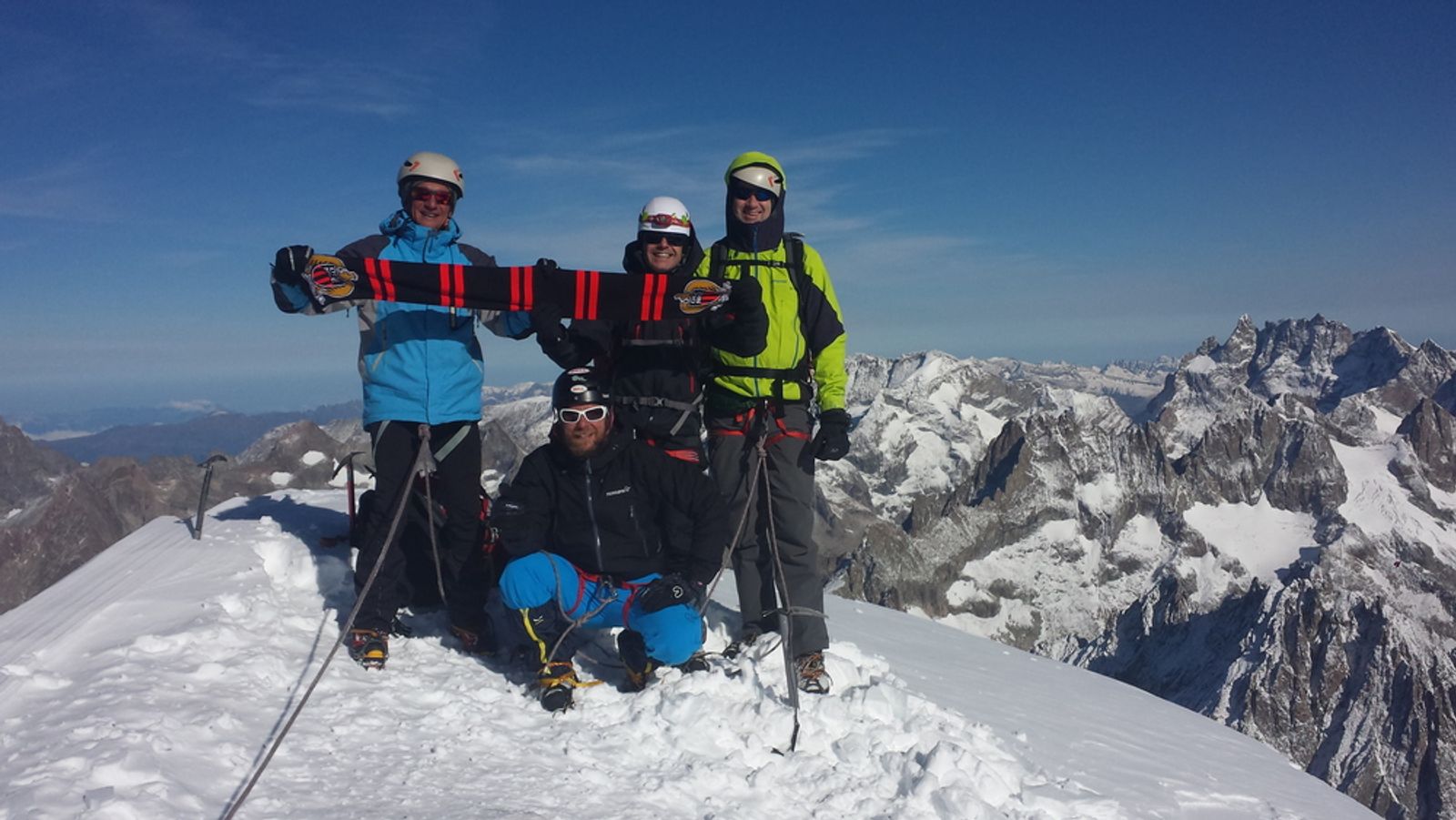Le groupe réuni au sommet enneigé du Dôme des Écrins sous un ciel bleu