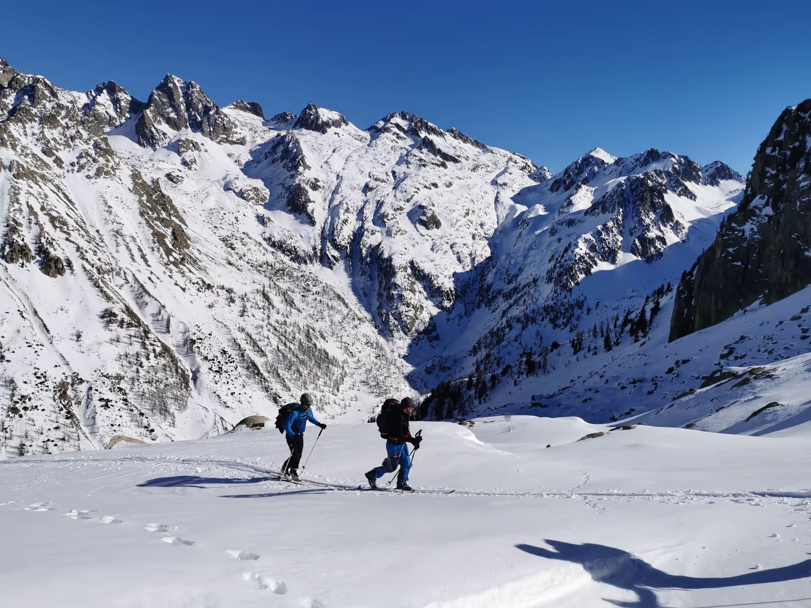 Deux skieurs traversant un vallon enneigé au cœur du Mercantour