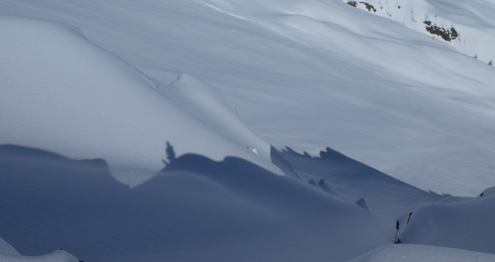 Ombres de randonneurs projetées sur une arête enneigée pendant la montée à la Blanche.