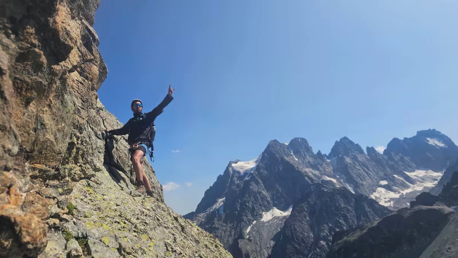 Participant progressant sur un passage rocheux lors d’un stage d’alpinisme dans les Écrins