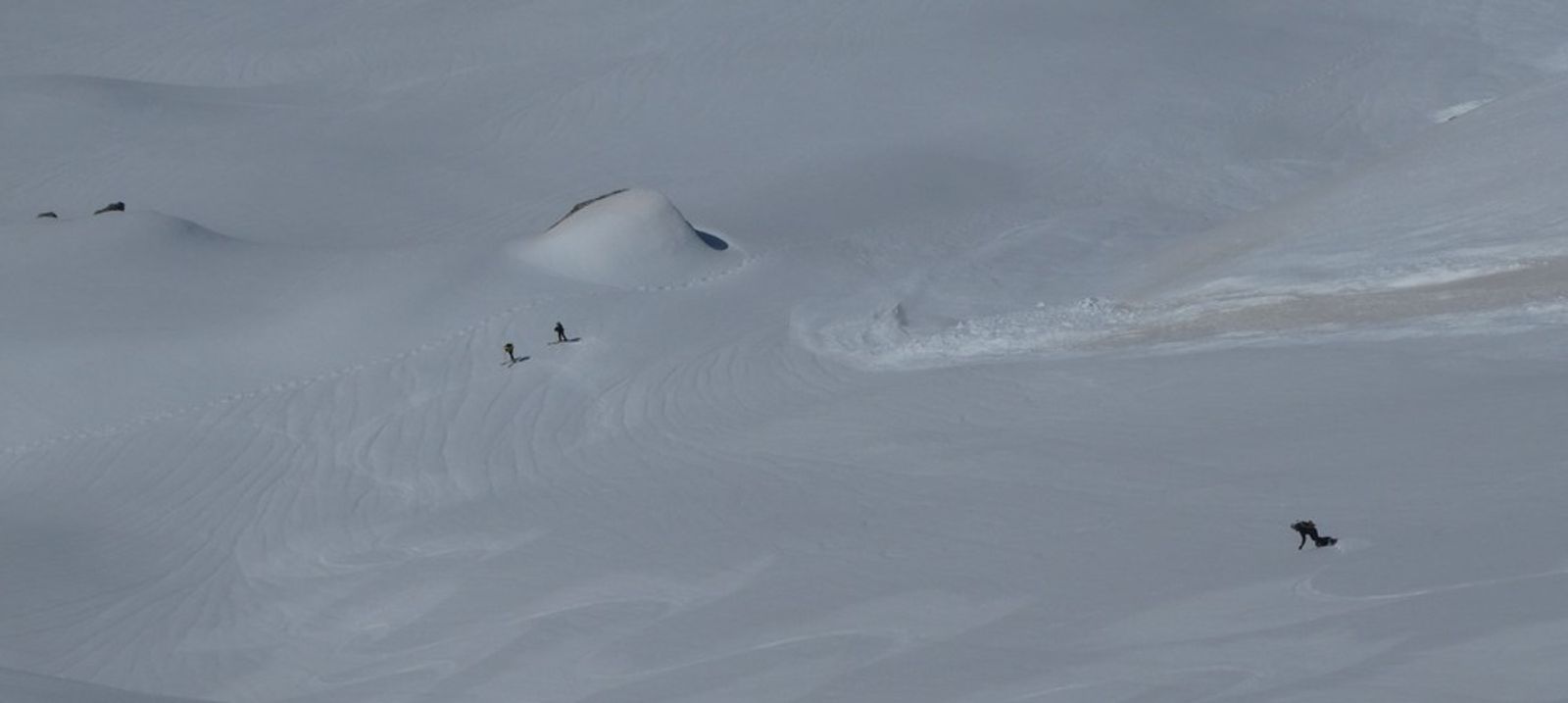 Splitboarder qui s'apprête à rejoindr deux skieurs arrêtés