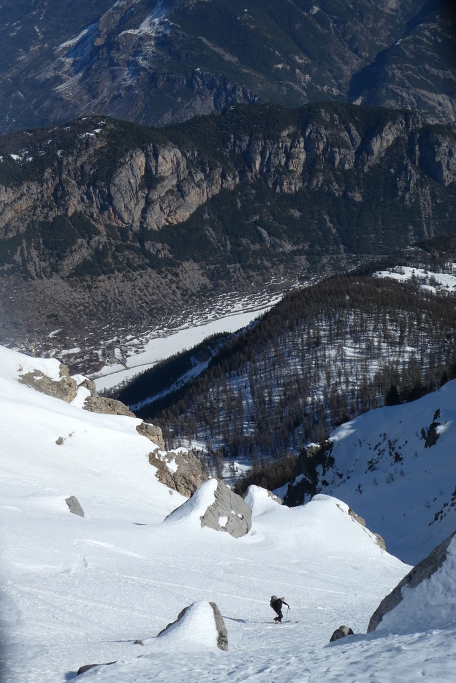 Skieur dans les pentes enneigées des Gourenqs, au-dessus de la vallée de Freissinières.