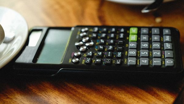 Calculator on a wooden table representing aged lead pricing and ROI analysis