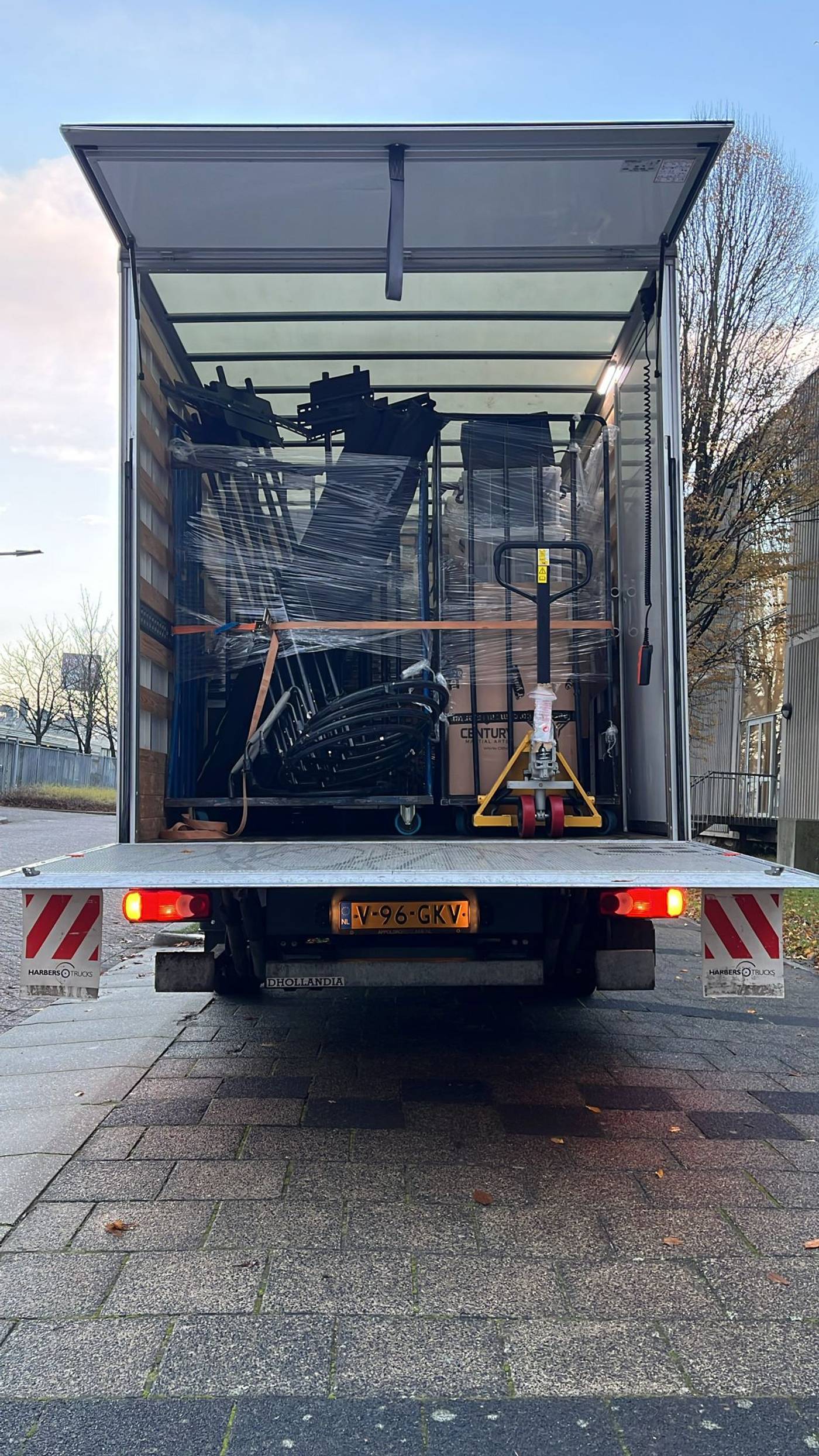 Transportbus met op de achtergrond bomen en een achtbaan