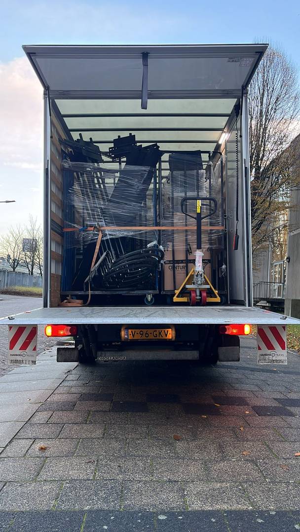 Transportbus met op de achtergrond bomen en een achtbaan