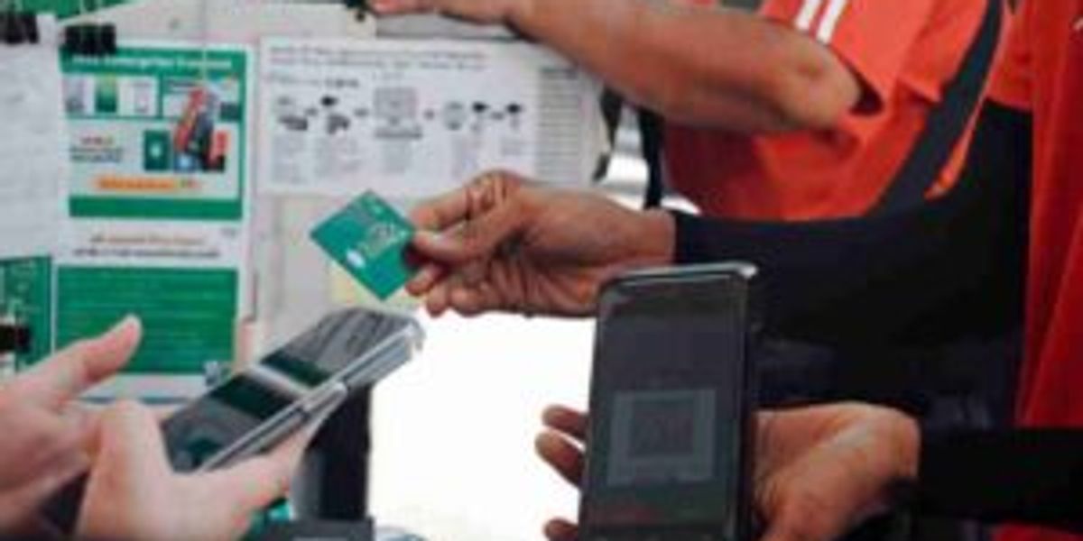someone paying by card and another person holding a mobile phone displaying a QR code