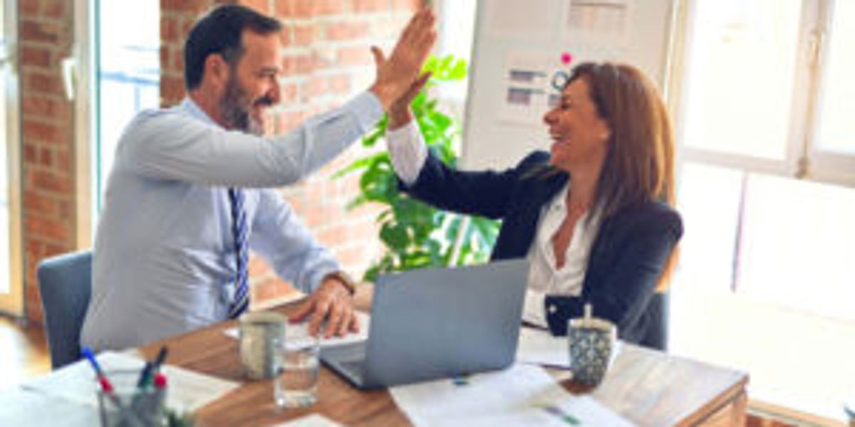 Office workers giving each other a high-five