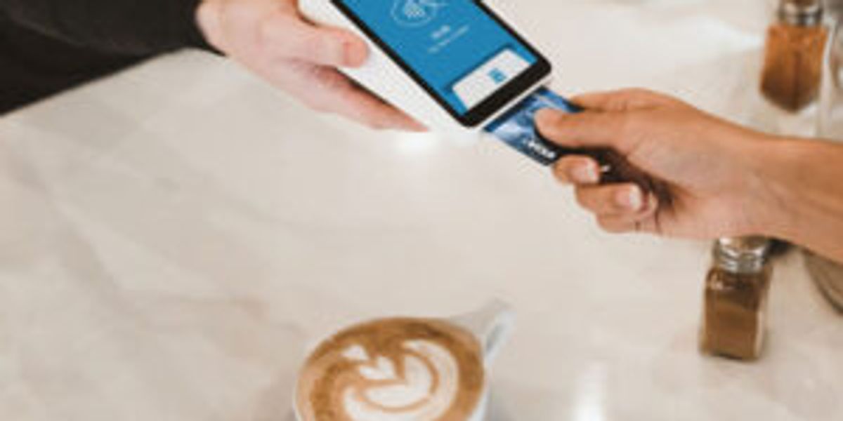Someone paying by card for a coffee