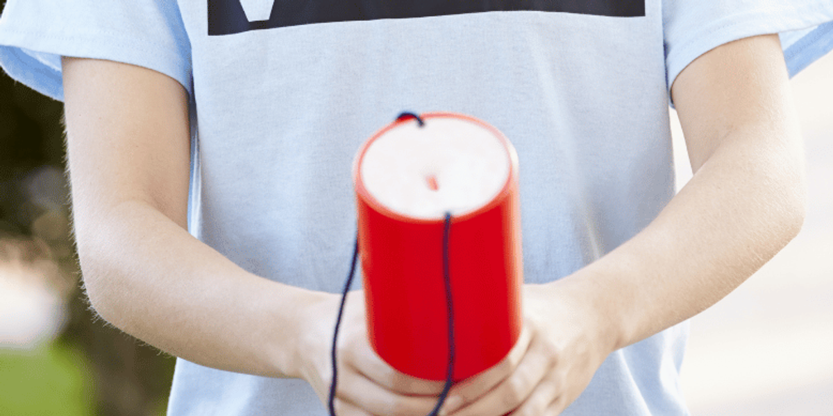 Person holding a charity donation tin wearing a t-shirt with the word volunteer on it