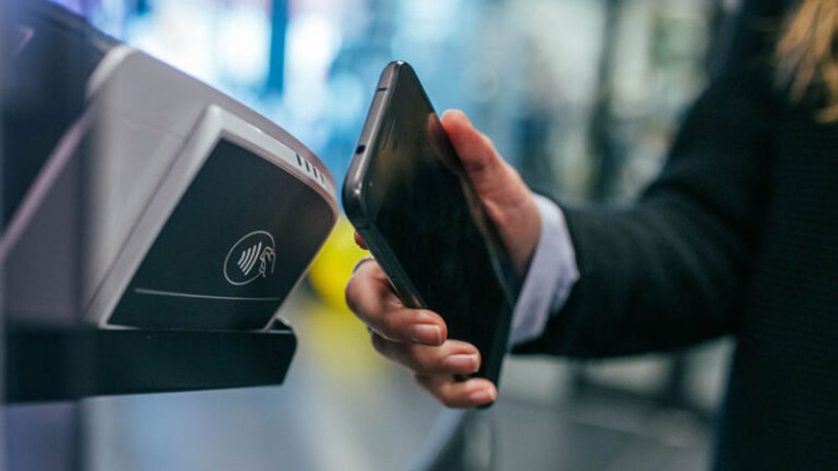 Person tapping their mobile phone to pay contactlessly