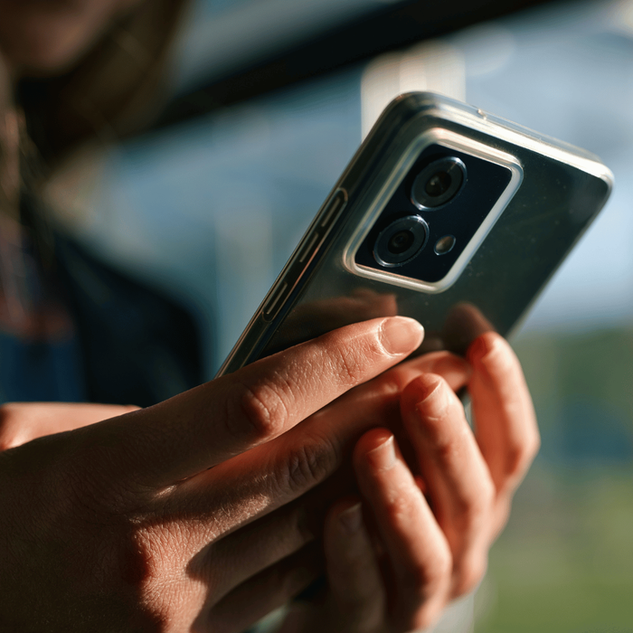 A pair of hands holding a mobile phone