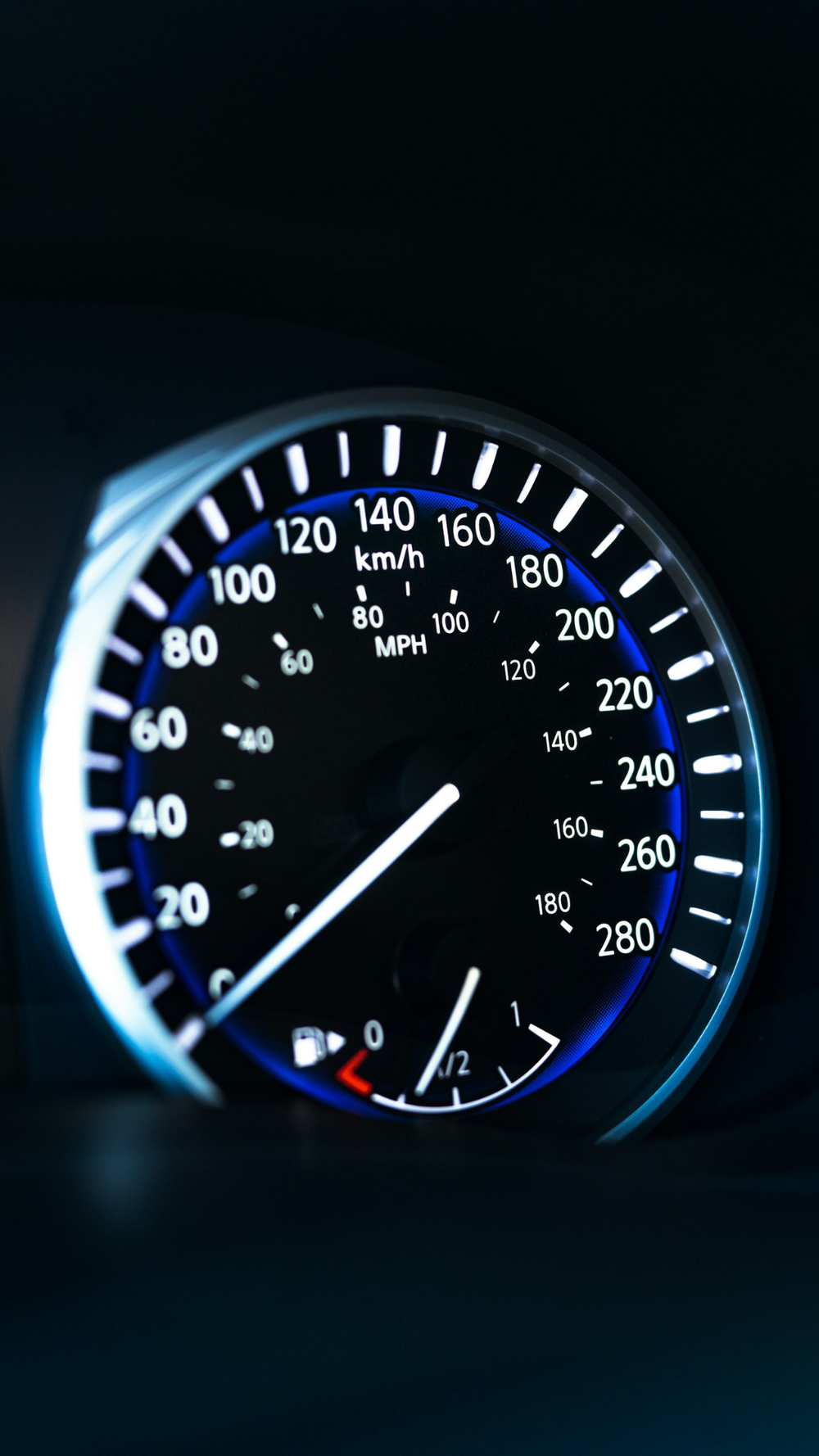 Painel de velocímetro de carro iluminado em azul, indicando velocidade em km/h, representando desempenho, controle e condução no contexto automotivo