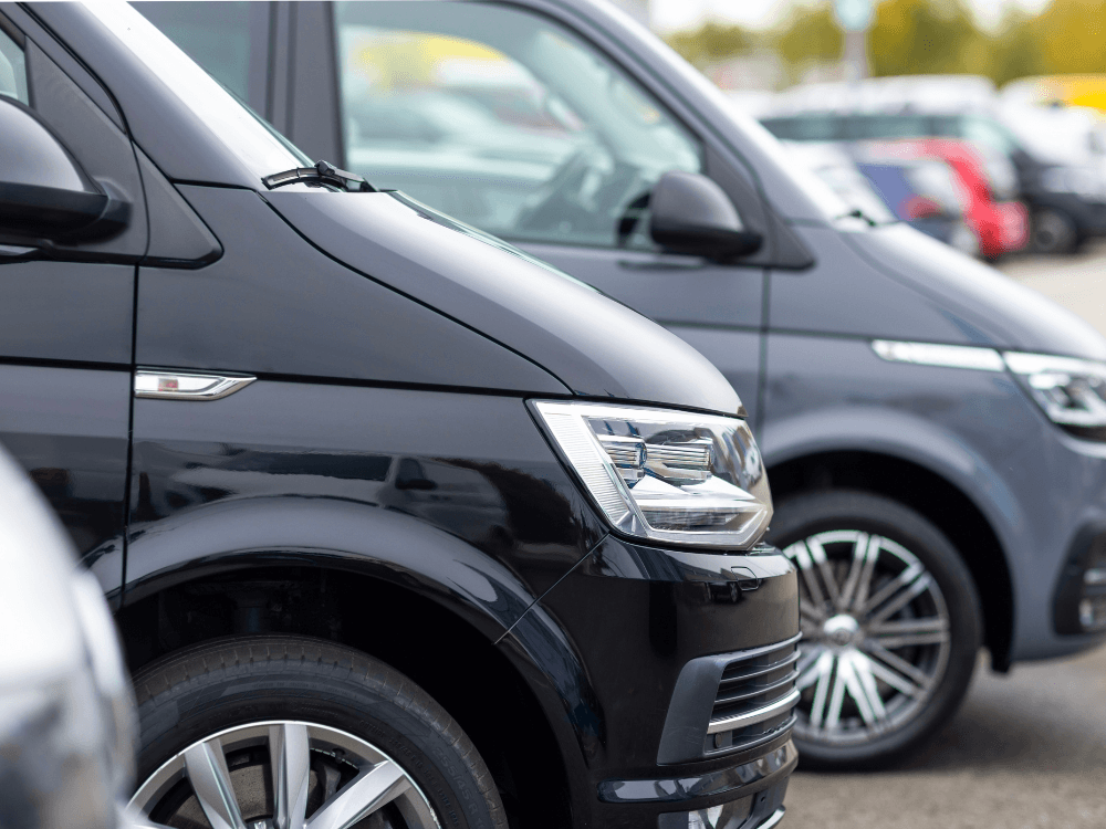 Carros estacionados em sequência, destacando diferentes modelos e a importância de verificar os dados antes da compra.