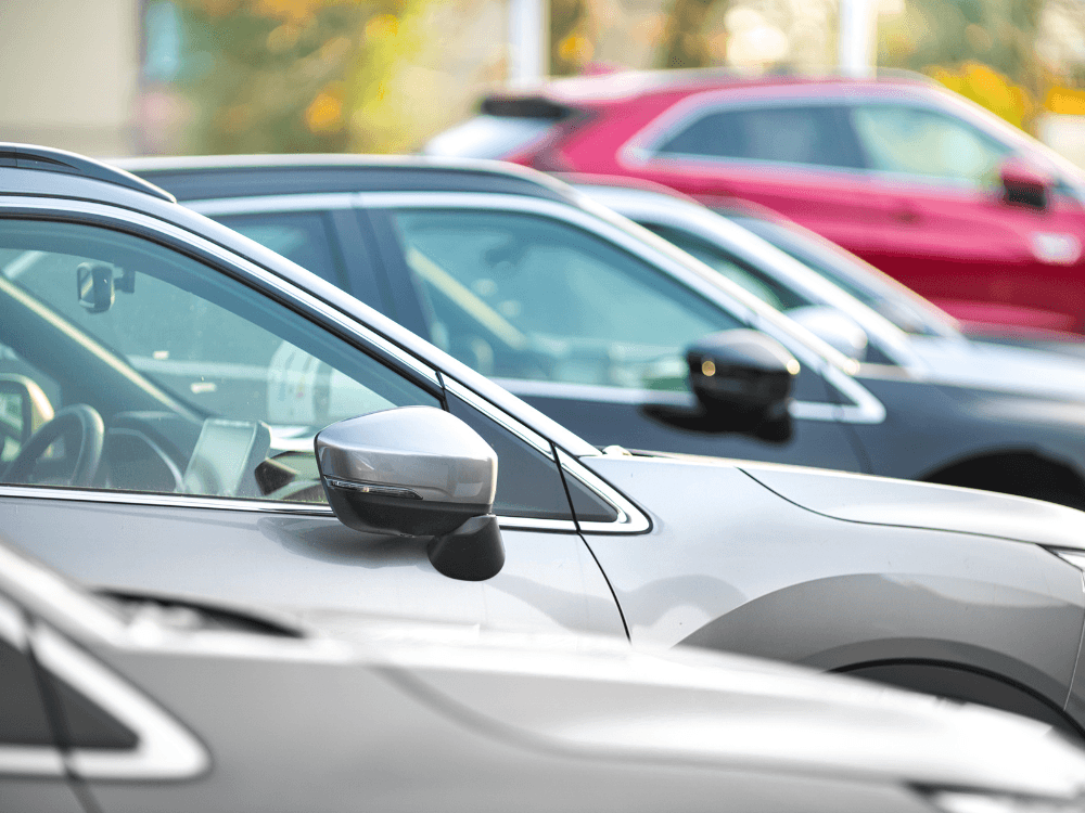 Carros de diferentes cores estacionados lado a lado, cenário que representa a consulta de informações sobre veículos.