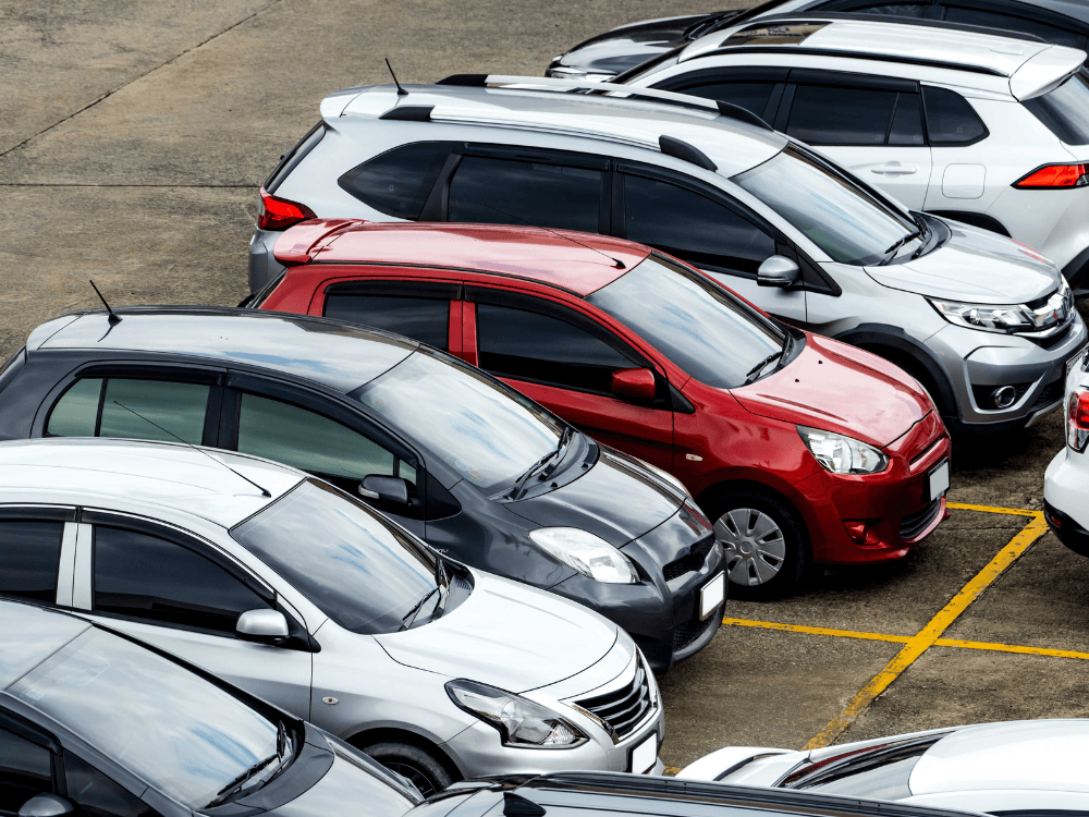 Vários carros estacionados lado a lado em uma área de veículos, representando opções disponíveis para compra no mercado automotivo.