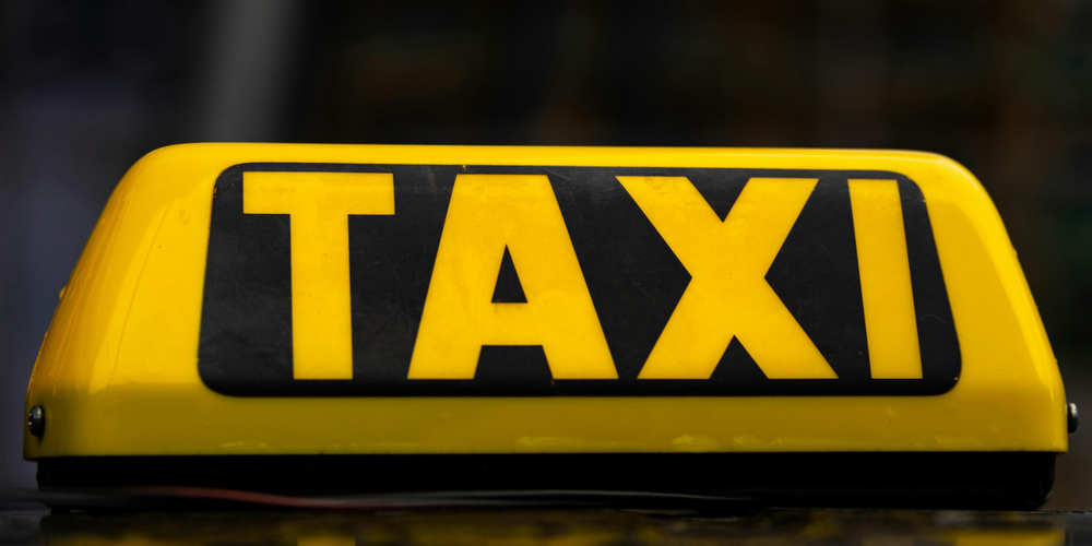Placa luminosa de táxi em amarelo e preto, símbolo utilizado em veículos de transporte de passageiros urbanos