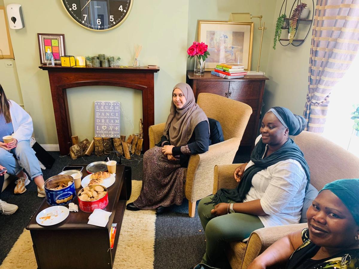 4 women sat in a living room 