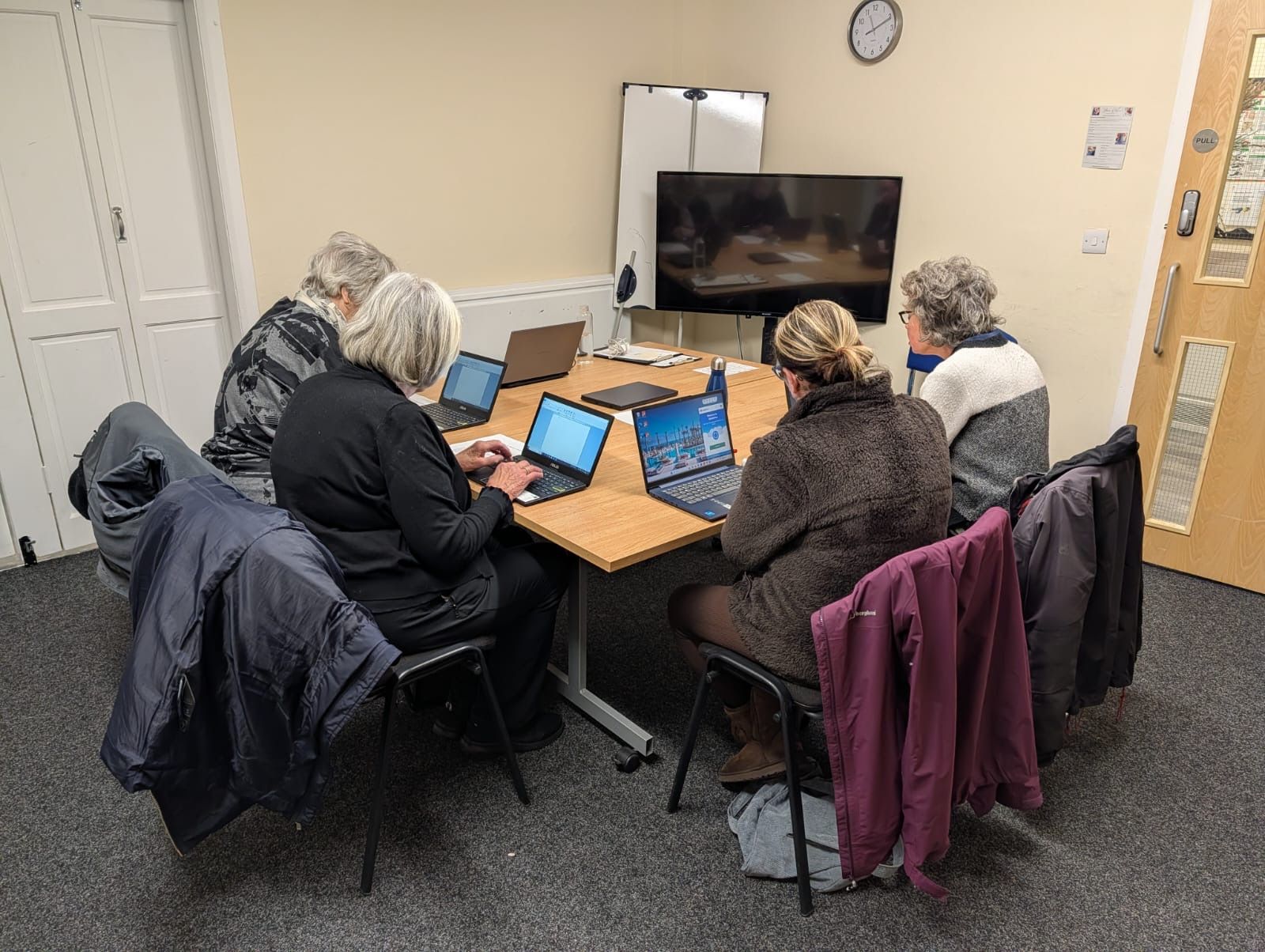four people sat around a desk