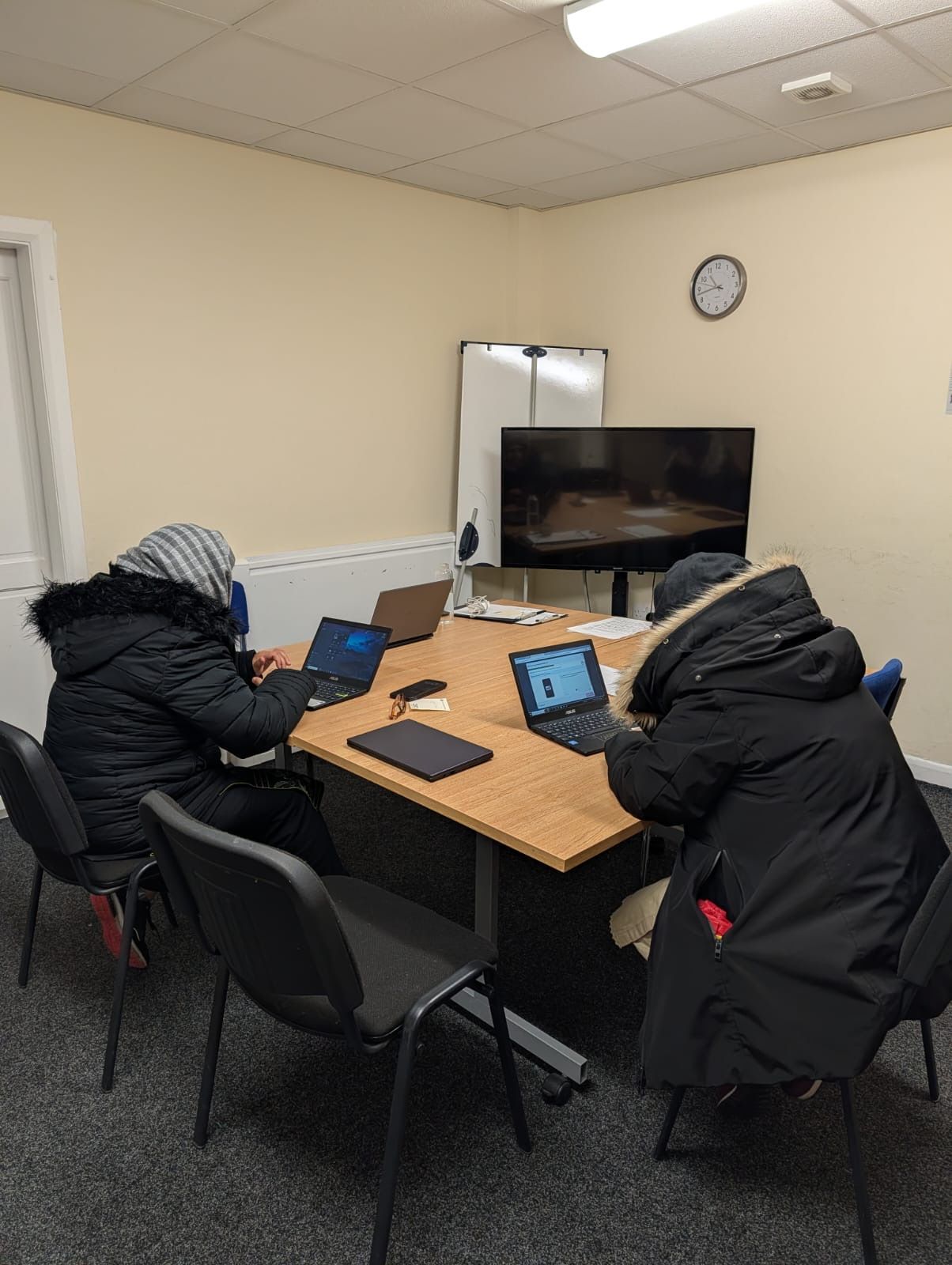 three people sat around a desk