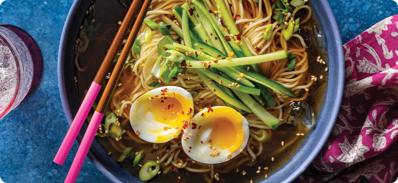 Bowl of noodles with egg and chopsticks
