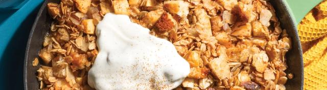 apple crisp in cast iron pan on blue table with yellow napkin
