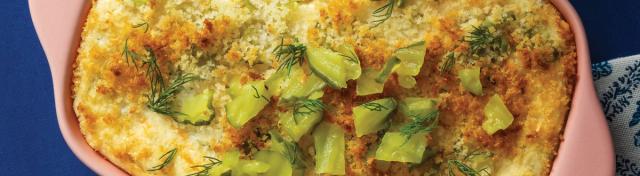 baked dip with pickle garnish in pink pan